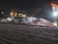 there is a lot of snow and buildings at night time in the mountains area of town