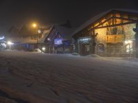 a man walks out to the lodge in a snowy night with snow piled on the ground