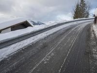 a snow covered road with some skis and trees on the side of it and snow capped hills in the background