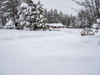 a lone skier in the snow outside a small cabin on a hill with trees covered in snow