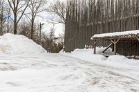 there is a wooden shelter in the middle of a snowy area with dirt piled up on the ground