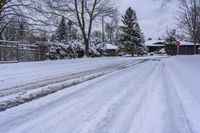 a snowy sidewalk with a stop sign on it in the middle of a neighborhood,