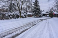 a snowy sidewalk with a stop sign on it in the middle of a neighborhood,