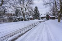 a snowy sidewalk with a stop sign on it in the middle of a neighborhood,