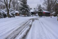 a snowy sidewalk with a stop sign on it in the middle of a neighborhood,