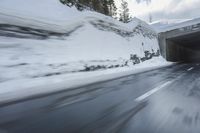 a blurry image of a road in an tunnel with rain, as viewed from the front seat of a car