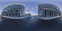 a street and some buildings and snow and blue sky and clouds behind them to depict a panorama