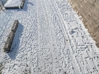 a person standing in the snow on the edge of a walkway at a lake bank