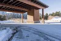 an empty garage and car port covered in snow in front of a high rise building