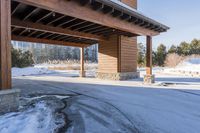 an empty garage and car port covered in snow in front of a high rise building