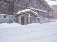 a tall brown wooden house with several windows in the snow near a road with a person walking up the sidewalk next to it