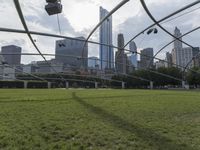 a goalie ball sitting in the middle of a soccer field overlooking a cityscape