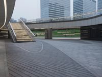an empty walkway and steps leading to many skyscrapers in the city park area of a city