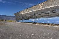 a solar panel on the side of a road in the desert with mountains in the background