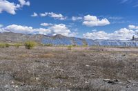 a large array of solar panels in the desert near some mountains on a bright day