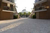 a very big nice looking walkway way with palm trees and buildings in the background for a very beautiful effect