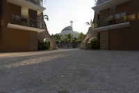 a very big nice looking walkway way with palm trees and buildings in the background for a very beautiful effect