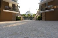 a very big nice looking walkway way with palm trees and buildings in the background for a very beautiful effect