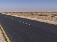 an empty highway in the middle of the desert with no cars on it, including a motorcycle