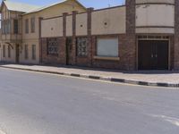 a building with the sign that reads to the right of the road is a closed street, with a yellow line on the road in front of it, and some buildings