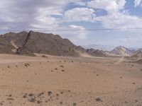 an empty desert landscape that is completely barren and full of dirt areas with mountains in the distance