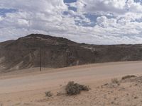 a person that is on a motorcycle in the middle of nowhere looking at a mountain