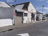 an arrow pointing in different directions in a street with some shops around the corner and cars parked along the side