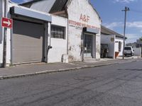 an arrow pointing in different directions in a street with some shops around the corner and cars parked along the side