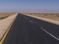 a lone road in the desert with no one on it looking forward or sideways,