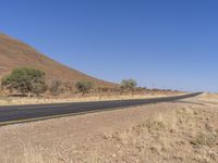 a lone highway with no cars and no buildings on the sides and there are hills