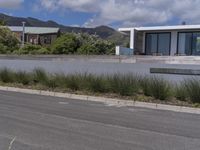 the sidewalk at the edge of a wide, empty street with a modern building in the background