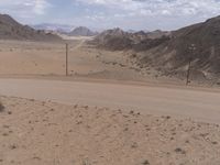 a red motorcycle is on the empty desert road looking at something that appears to be dirt