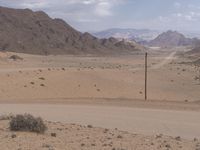 a red motorcycle is on the empty desert road looking at something that appears to be dirt