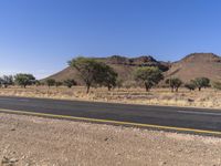 there is a large empty road with some mountains in the background in the desert areas