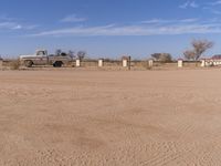 an old truck is parked along a road in the desert near a rail line lined with rails