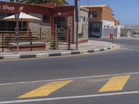 a traffic light on the corner with yellow lines in front of the building and some buildings