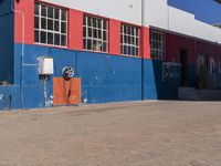 a fire hydrant sits on the sidewalk in front of a building with a bike