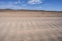 a desert area with some very sparse, dry grass and sparse sand on it's sides