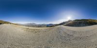 a wide - angle view of a road through the mountains that you see on an angle