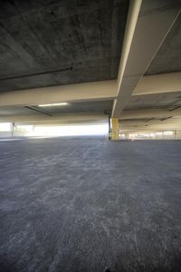 a very large empty parking garage, showing the floor and top half in grey color