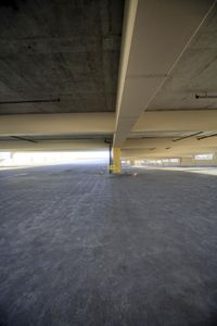 a very large empty parking garage, showing the floor and top half in grey color