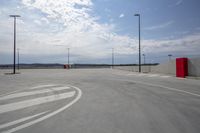 a paved parking lot with an open space, next to a ramp, and multiple outdoor light poles