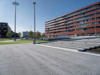 a wide open road with stairs and concrete buildings in the background on a sunny day