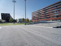 a wide open road with stairs and concrete buildings in the background on a sunny day