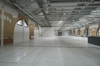 a large empty warehouse room with windows and exposed ceilings, concrete floors and exposed ceiling