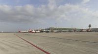 airplanes are sitting outside of an airport in a sunny day's light with a cloudy sky