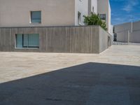 the gray concrete walls of a building have a line of steps on the left side