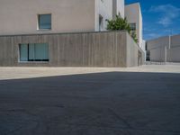 the gray concrete walls of a building have a line of steps on the left side