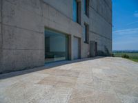 the gray concrete walls of a building have a line of steps on the left side