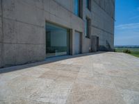 the gray concrete walls of a building have a line of steps on the left side